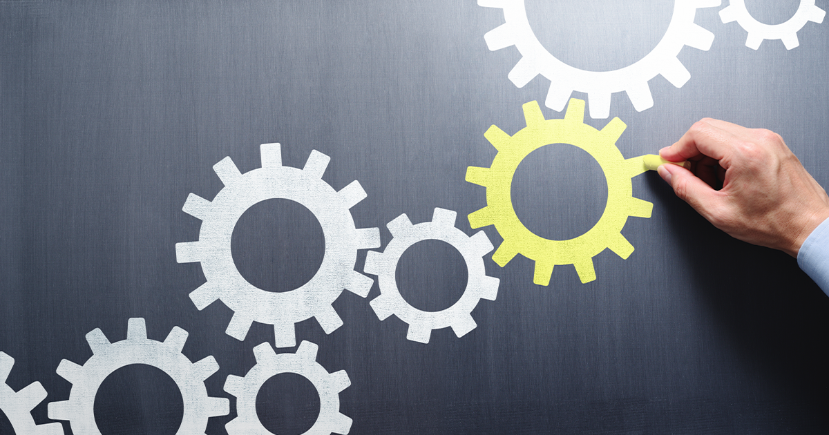 Abstract image of white gears with yellow gear highlighted